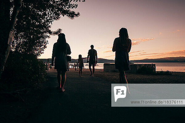 USA  Tahoe City  Rear view of people walking near Lake Tahoe at sunset