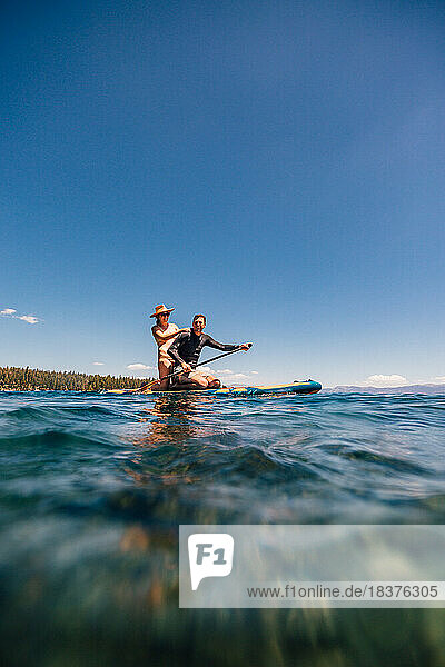 USA  California  Smiling couple paddleboarding on Lake Tahoe