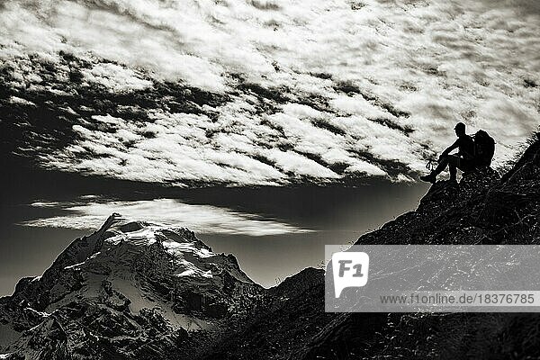 Mountaineer in backlight with cloudy sky in front of Ortler summit massif  Trafoier Tal  Meran  Vinschgau  South Tyrol  Italy  Europe