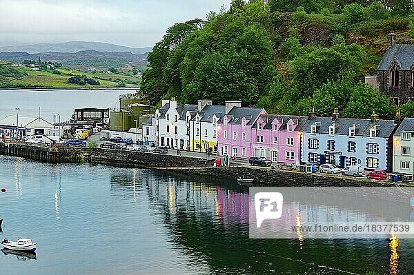 Farbenfrohe Häuser spiegeln sich im ruhigen Wasser eines Hafens  Abenddämmerung  Portree  Isle of Skye  Schottland  Großbritannien  Europa