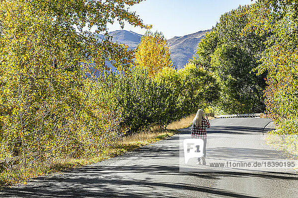 mature blond woman walks country road in fall near Sun Valley Idaho
