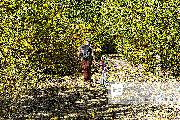 father and daughter walk rural path in fall near Sun Valley idaho