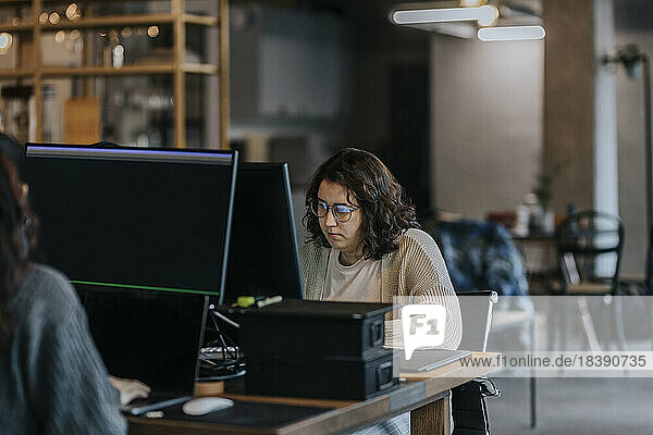 Junge weibliche Programmiererinnen arbeiten an Computern am Schreibtisch in einem Start-up-Unternehmen