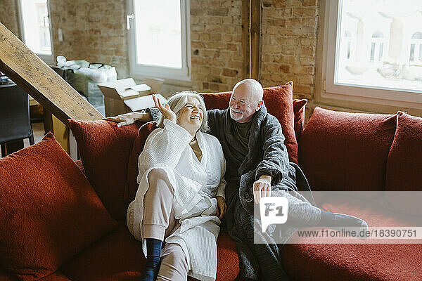 Glückliches älteres Paar verbringt seine Freizeit auf dem Sofa zu Hause
