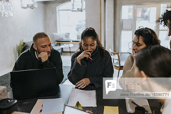 Multiracial colleagues planning business strategy at desk in startup company