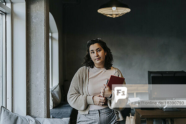 Porträt einer jungen Geschäftsfrau mit digitalem Tablet im Büro stehend