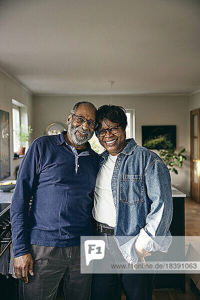 Porträt eines lächelnden älteren Paares  das zu Hause zusammensteht