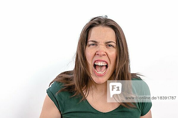 Nahaufnahme einer wütenden Frau  die in die Kamera schaut und ihre Zähne zeigt  auf weißem Hintergrund