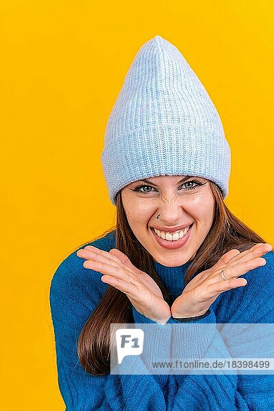 Close up Porträt der jungen Frau  fröhlich vorgelben Studio Hintergrund in blauen Wollpullover
