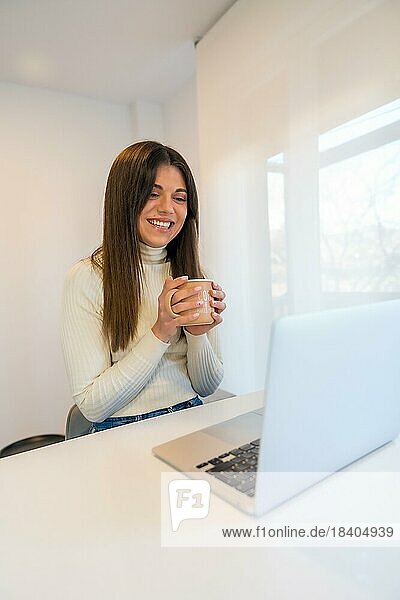 Geschäftsfrau arbeitet an einem Computer mit einem heißen Kaffee  Geschäft  Heimbüro  Telearbeit