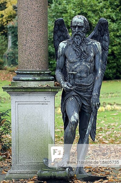 Statue des Todesengels  des alten Vaters Zeit  des Sensenmannes mit Sense und Sanduhr auf einem Friedhof im Herbst