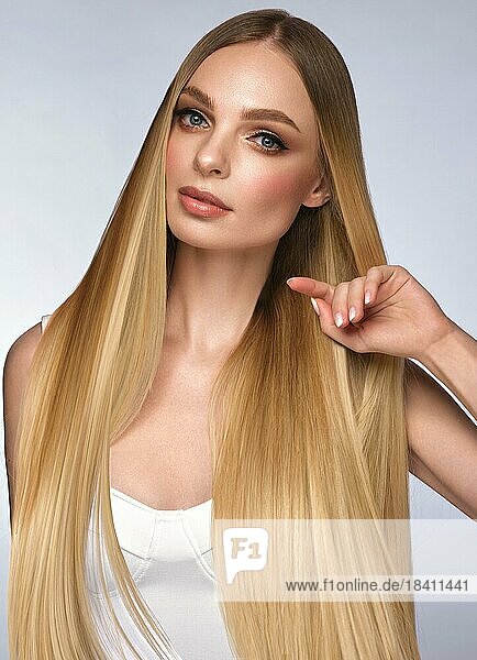 Schönes blondes Mädchen mit einem perfekt glatten Haar und klassischem Make up. Schönheit Gesicht und Haar. Bild im Studio aufgenommen