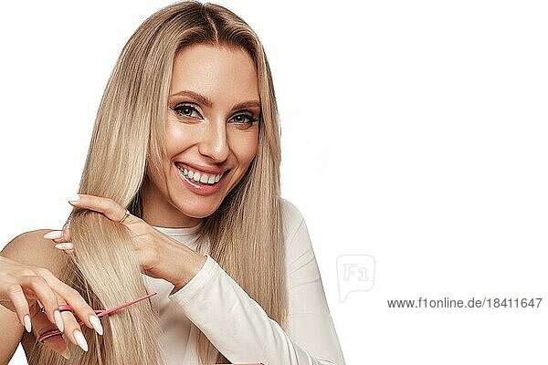 Schöne blonde Mädchen mit einem perfekt Haar  und klassische Make up mit Schere in der Hand. Schönheit Gesicht und Haar. Bild im Studio aufgenommen