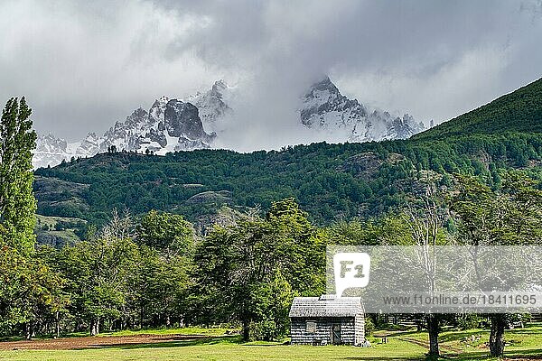 Mit Schindeln gedecktes Holzhaus vor schneebedeckten Bergen  Villa Cerro Castillo  Cerro Castillo-Nationalpark  Aysen  Patagonien  Chile  Südamerika