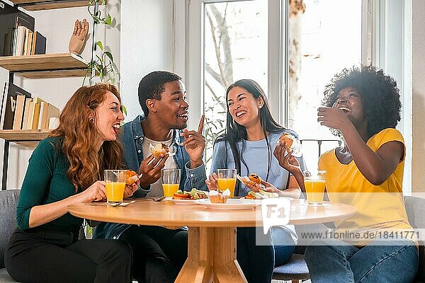 Freunde bei einem Frühstück mit Orangensaft und Muffins zu Hause  um gemeinsam gute Nachrichten zu feiern