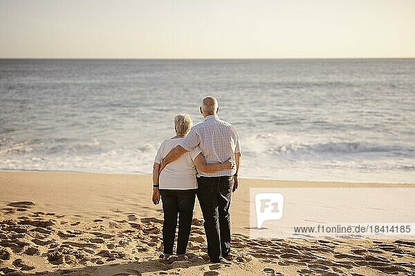 Älteres Paar  das sich am Strand umarmt  von seinem Rücken aus gesehen
