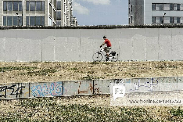 Ein Radfahrer an der Berliner Mauer zeichnet sich ab an der East Side Gallery in Berlin  26.06.2022.  Berlin  Deutschland  Europa