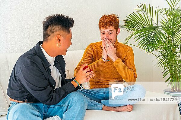 Beautiful gay couple being romantic on sofa  lgbt concept  man asking for marriage