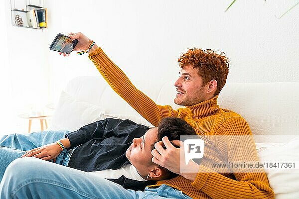 Schöne Homosexuell Paar wird romantisch drinnen zu Hause auf dem Sofa  Homosexuell Paar Selfie  lgbt Konzept