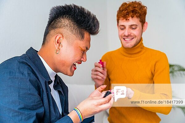Schöne Homosexuell Paar tun Make up  ihre Nägel zu malen und Spaß haben drinnen zu Hause  lgbt Konzept