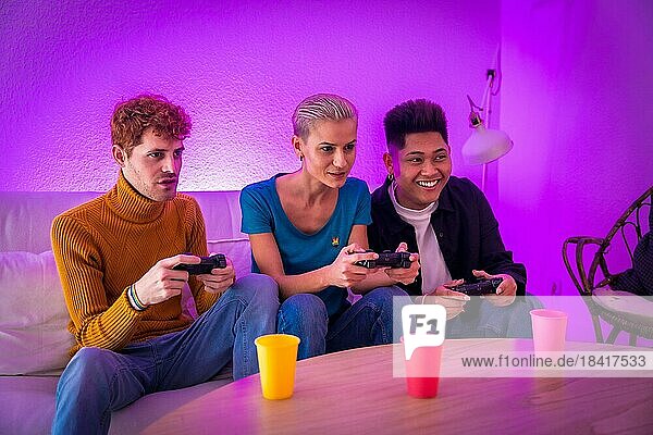 Eine Gruppe junger Freunde spielt gemeinsam Videospiele auf dem Sofa zu Hause