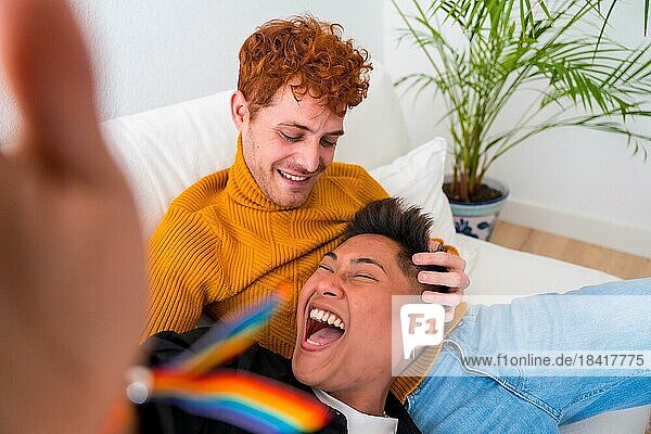 Schönes homosexuelles Paar  das drinnen zu Hause auf dem Sofa romantisch ist  homosexuelles Paar  das Selfie lachend macht  lgbt Konzept
