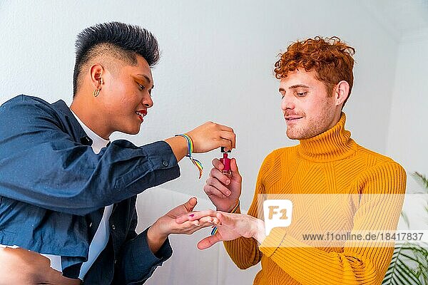 Beautiful gay couple doing makeup  painting their nails and having fun indoors at home  lgbt concept