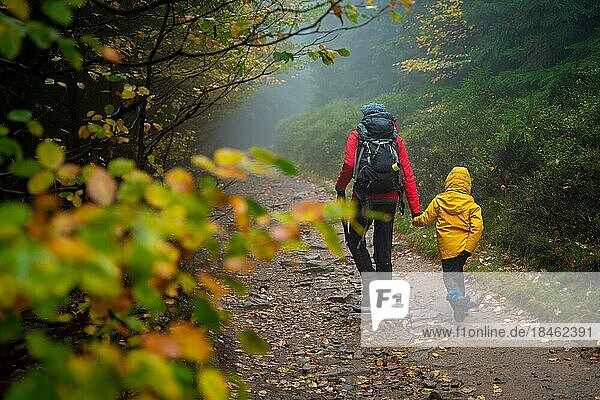 Mum and her little son go on a mountain trail in wet autumn weather. Polish mountains  Poland  Europe