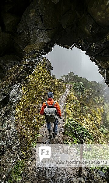 Wanderer im Nebel  Tunnel am Wanderweg  Pico Arieiro zum Pico Ruivo Wanderung  schmaler ausgesetzter Wanderweg an Felsenklippe  Zentralgebirge Madeiras  Madeira  Portugal  Europa