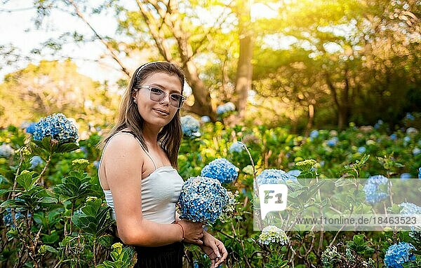 Lächelnde Frau in einem Hortensienfeld. Porträt einer jungen Frau in einem Hortensiengarten  Schönes Mädchen in einer natürlichen Blumengärtnerei. El Crucero  Managua  Nicaragua  Mittelamerika