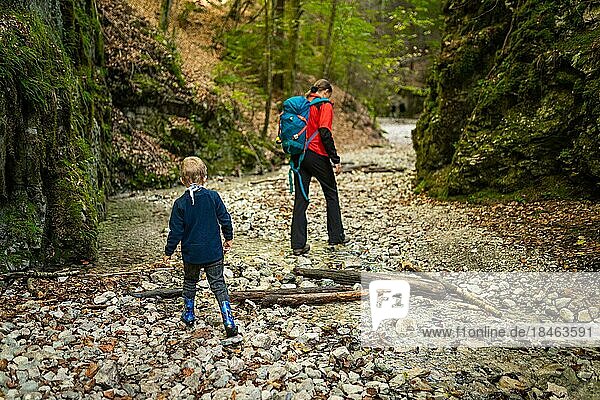 Zwei Rucksacktouristen (eine Frau mit einem kleinen Sohn) wandern entlang eines Baches in einer Schlucht des Slowakischen Paradies Nationalparks  Slowakei  Slowacki Raj Nationalpark  Slowakei  Europa