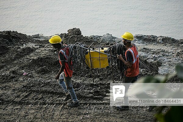 Guwahati  Indien. 27. März 2023. Bauarbeiter bei der Herstellung von Betonmasten in der Nähe des Brahmaputraflusses in Guwahati