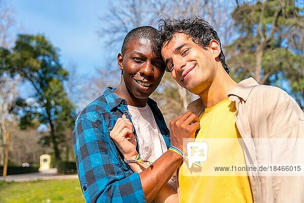 Portrait of multiethnic gay male couple on a romantic walk in the park  lgbt concept