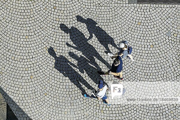 Vier Personen aus der Vogelperspektive  eine Familie geht über einen Platz mit Pflastersteinen  Schatten  Symbolfoto  Stuttgart  Baden-Württemberg  Deutschland  Europa