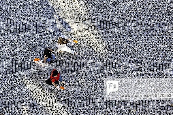Drei Personen aus der Vogelperspektive  Menschen mit Einkaufstüten gehen über einen Platz mit Pflastersteinen  Symbolfoto  Stuttgart  Baden-Württemberg  Deutschland  Europa