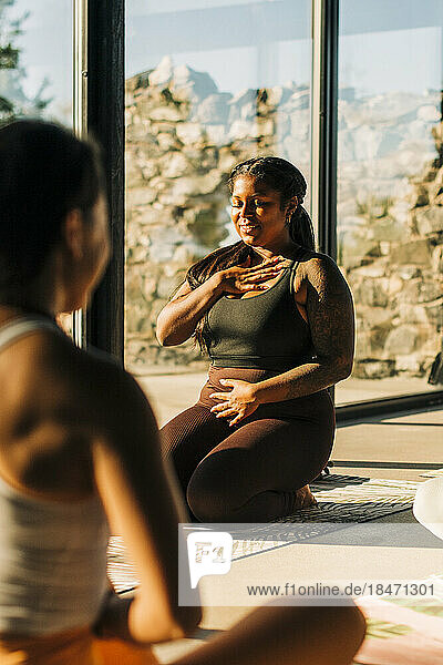 Lächelnde Frau beim Üben von Atemübungen in einer Yogaklasse im Retreat Center