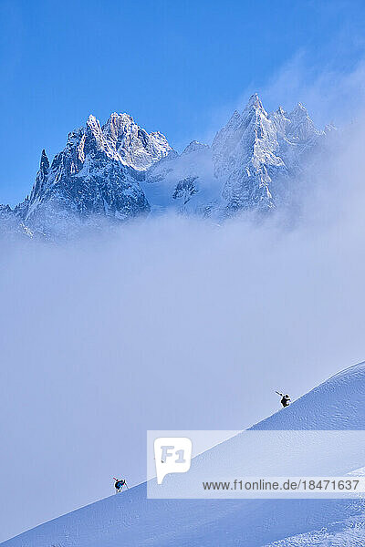 Skiers hiking on snow covered mountain