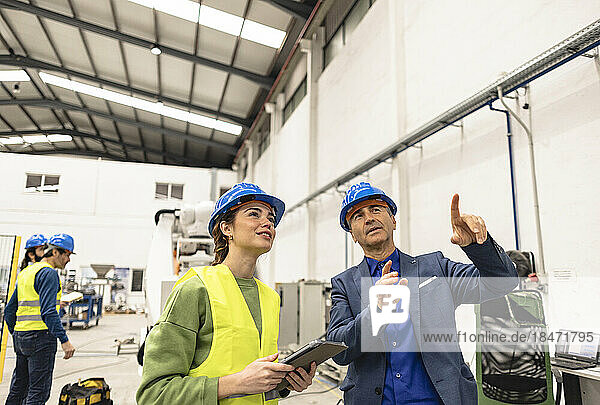 Lächelnde Ingenieure diskutieren in der Robotikfabrik