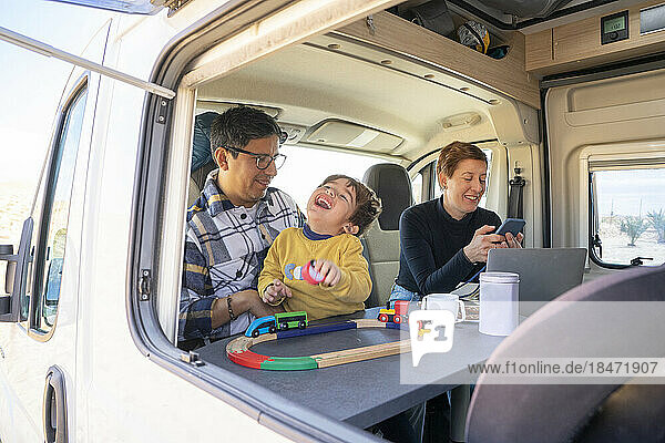 Happy son enjoying with parents in camper van