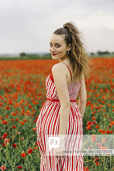 Smiling young woman at poppy field