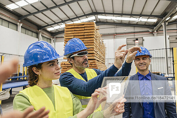 Engineer wearing smart glasses with colleagues in robotics factory
