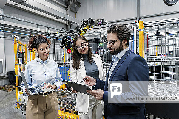 Smiling business colleagues having discussion in factory