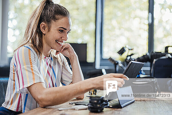 Smiling businesswoman using tablet PC at desk