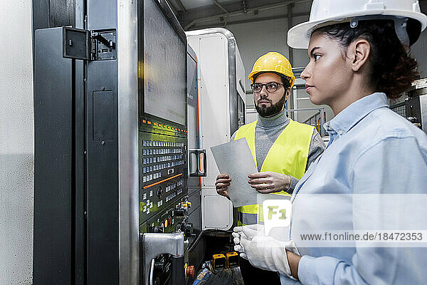 Business people working on machine controls in factory