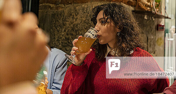 Young woman drinking beer at restaurant