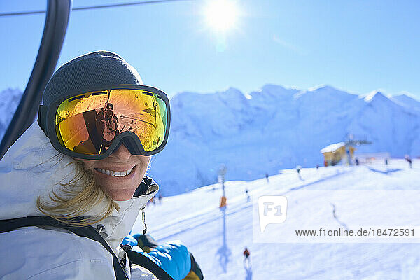 Happy woman with ski goggles on sunny day