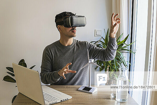 Geschäftsmann mit Virtual-Reality-Simulator gestikuliert im Büro