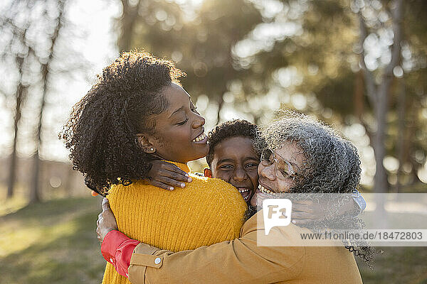 Happy multi-generation family embracing and having fun in park