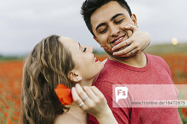 Loving young couple enjoying at poppy field