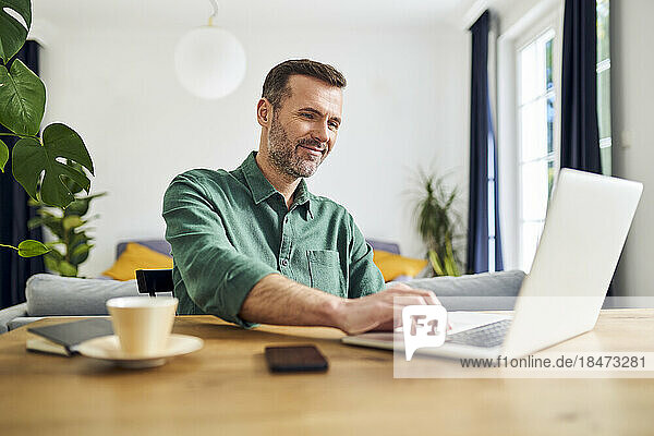 Business working with laptop from home sitting at table